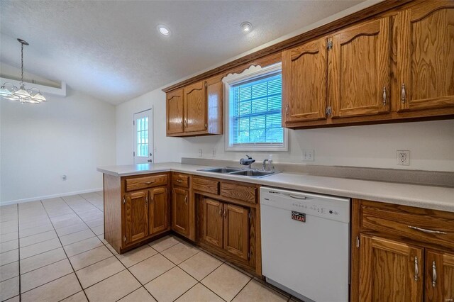 kitchen featuring a wealth of natural light, brown cabinetry, a sink, dishwasher, and a peninsula