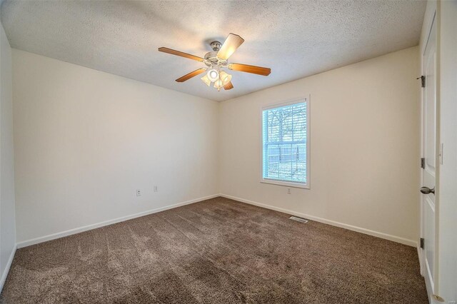 carpeted spare room featuring ceiling fan, a textured ceiling, visible vents, and baseboards