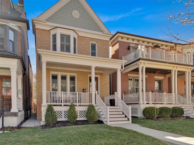 view of front facade with a porch, a front yard, and brick siding