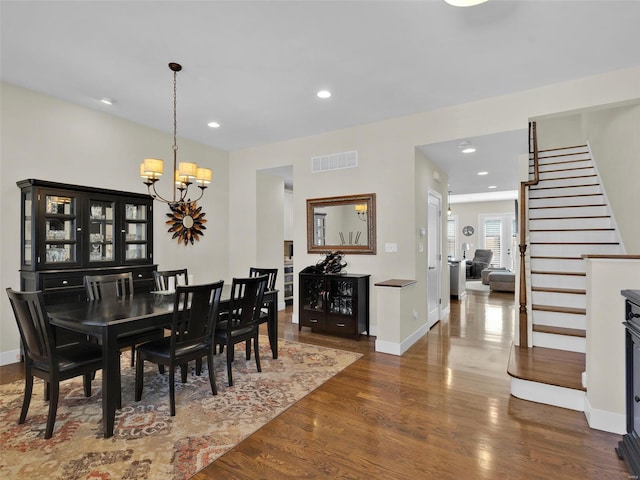 dining room featuring visible vents, dark wood-type flooring, stairs, a notable chandelier, and recessed lighting