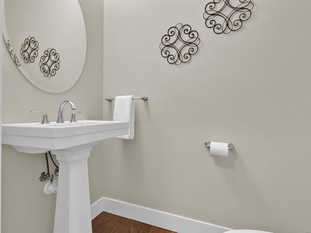 bathroom with wood finished floors and baseboards