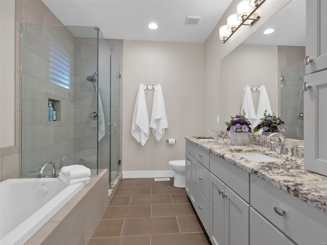 bathroom featuring toilet, double vanity, a sink, and visible vents