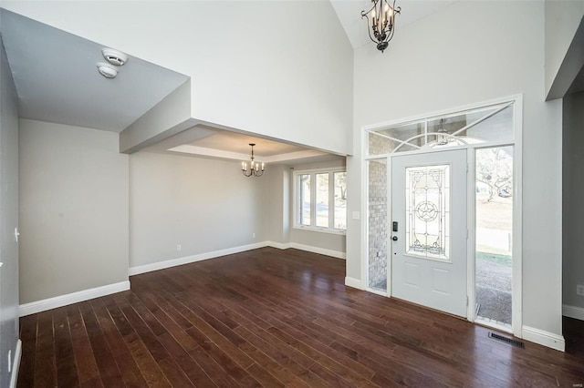 entrance foyer with an inviting chandelier, wood finished floors, and baseboards