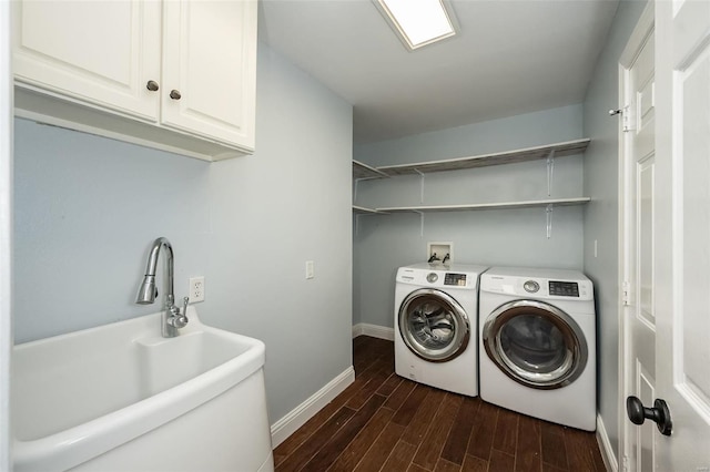 laundry area featuring baseboards, dark wood finished floors, separate washer and dryer, cabinet space, and a sink