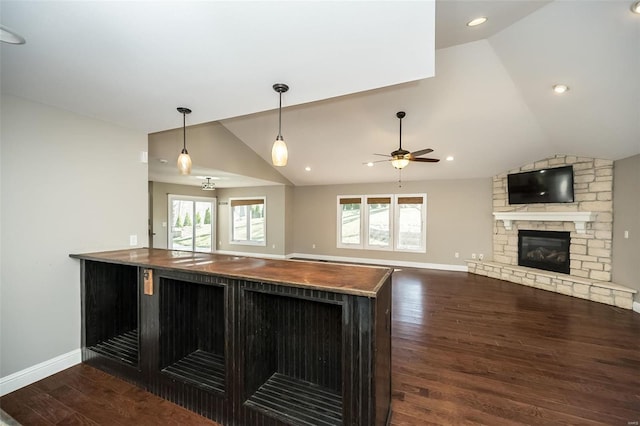 kitchen with lofted ceiling, wood finished floors, open floor plan, a fireplace, and baseboards