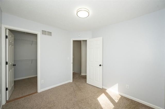 unfurnished bedroom with a closet, visible vents, carpet flooring, and baseboards