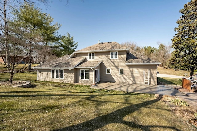 rear view of property with a yard and a patio area