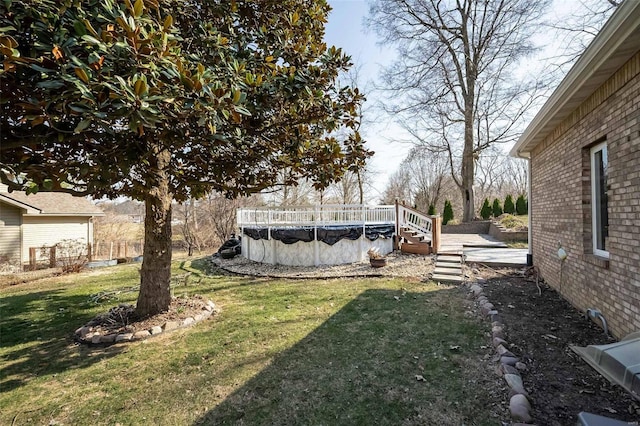 view of yard featuring a covered pool and a wooden deck