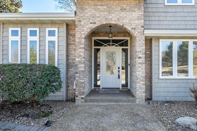 entrance to property featuring brick siding