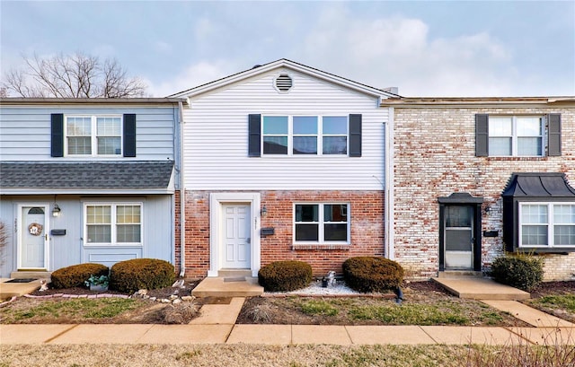 townhome / multi-family property with brick siding and roof with shingles