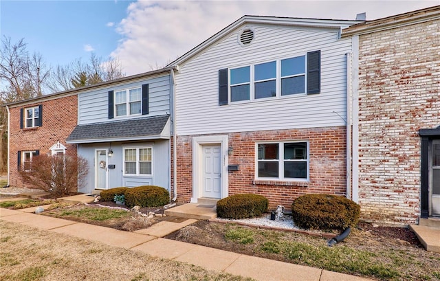 multi unit property featuring brick siding and a shingled roof