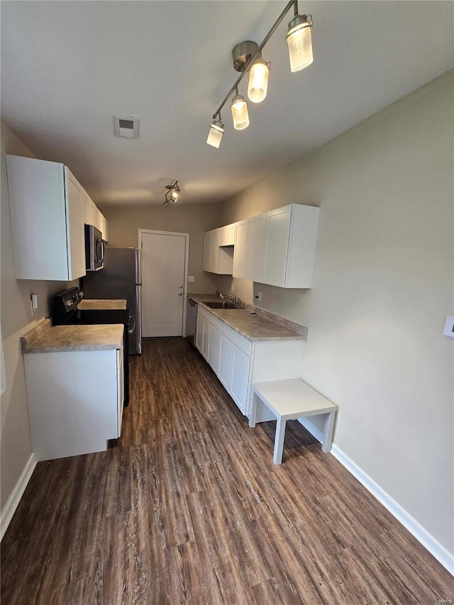 kitchen with baseboards, a sink, white cabinetry, and dark wood-style flooring