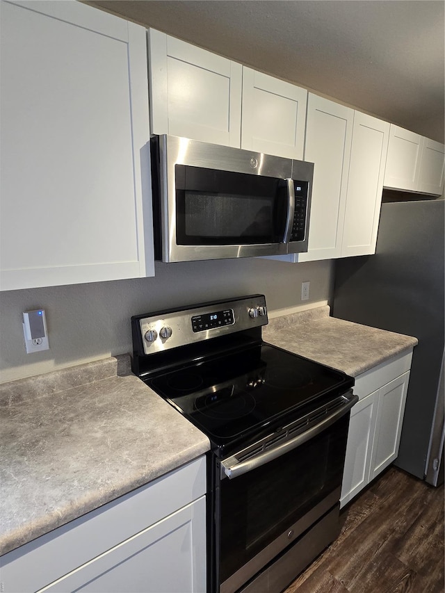 kitchen with light countertops, white cabinetry, dark wood-style flooring, and stainless steel appliances