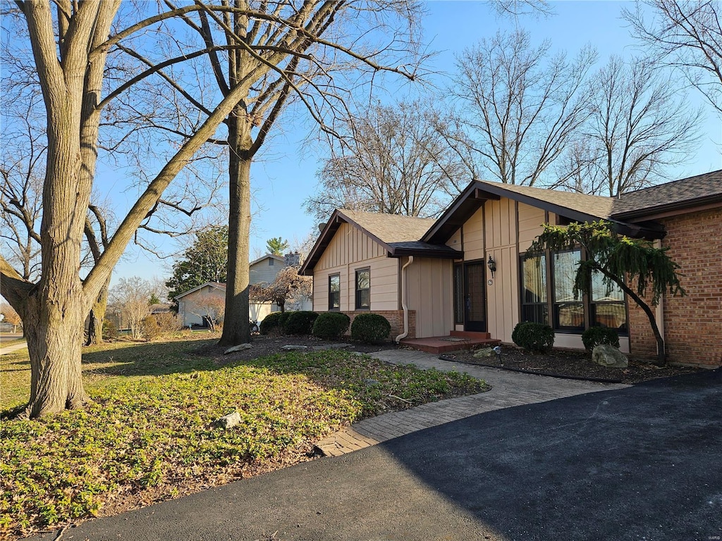 view of home's exterior with brick siding and board and batten siding