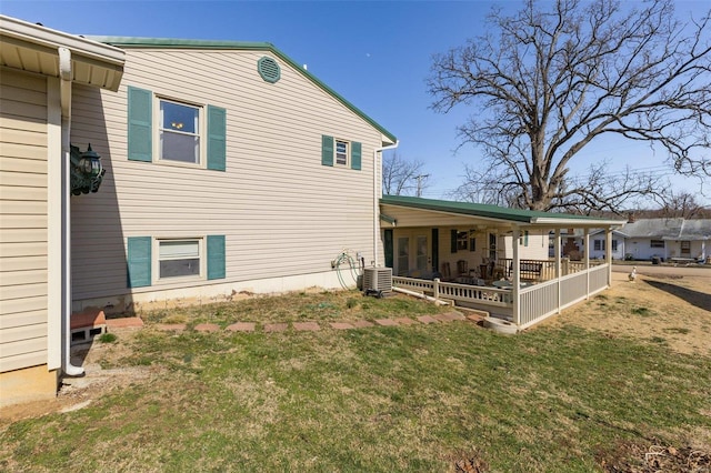 back of house featuring a lawn and central AC unit