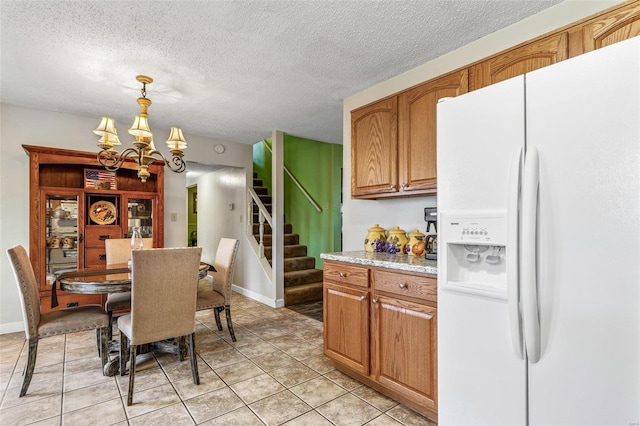 dining area with stairway, an inviting chandelier, light tile patterned flooring, a textured ceiling, and baseboards