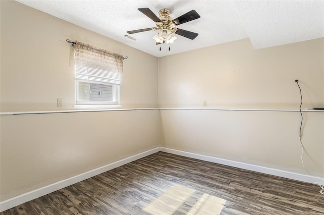 empty room with visible vents, a ceiling fan, a textured ceiling, wood finished floors, and baseboards