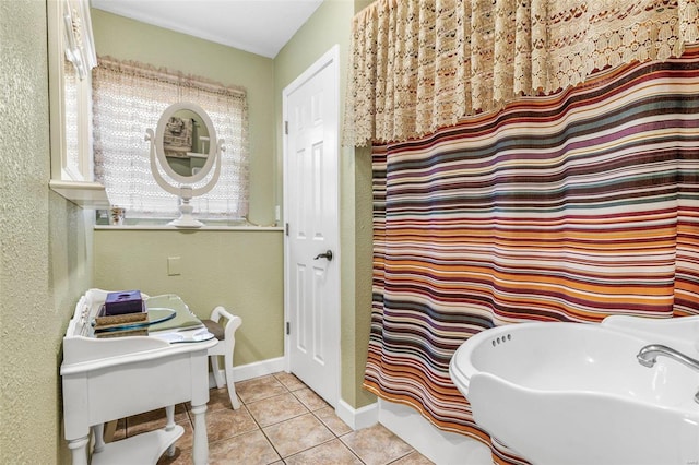 full bathroom featuring tile patterned flooring, a sink, and baseboards