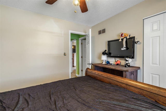 bedroom with a ceiling fan, visible vents, and a textured ceiling