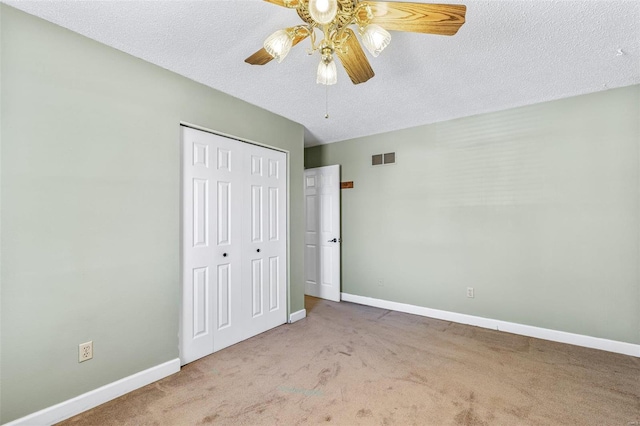 unfurnished bedroom featuring carpet, a closet, visible vents, and baseboards