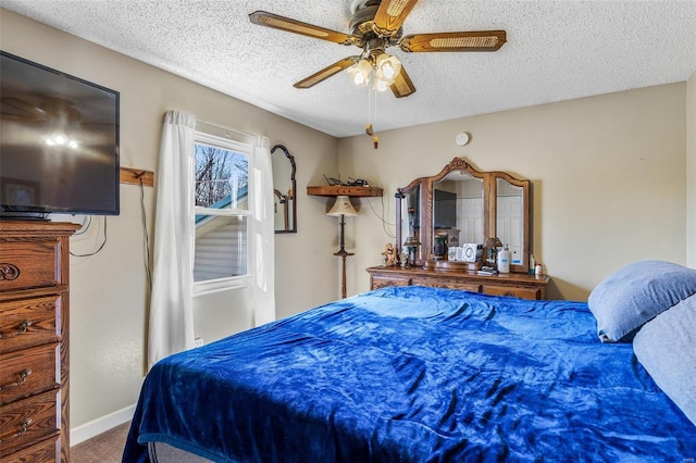 carpeted bedroom with a textured ceiling, ceiling fan, and baseboards