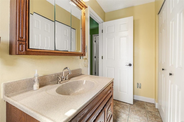 bathroom featuring tile patterned flooring, vanity, and baseboards