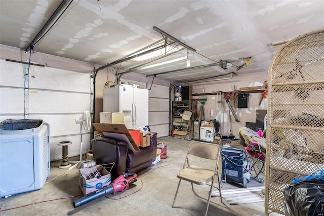 garage featuring white refrigerator with ice dispenser and independent washer and dryer