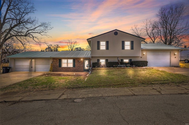 tri-level home with an attached garage, driveway, and a front yard