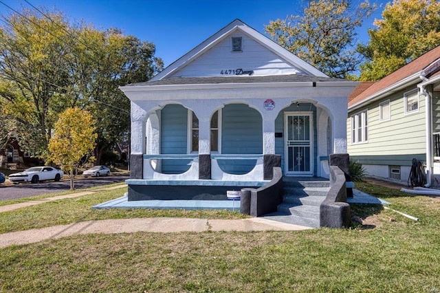 view of front of property with a porch and a front lawn