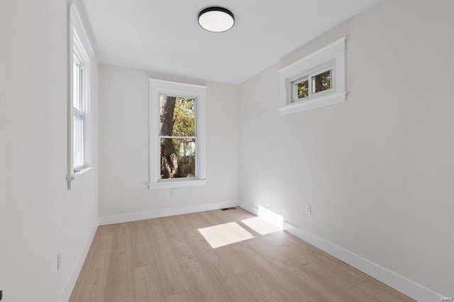 empty room with baseboards and wood finished floors