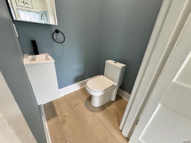 bathroom featuring baseboards, toilet, and wood finished floors