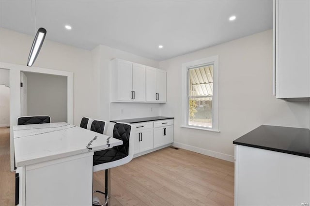 laundry room featuring light wood-type flooring, baseboards, and recessed lighting