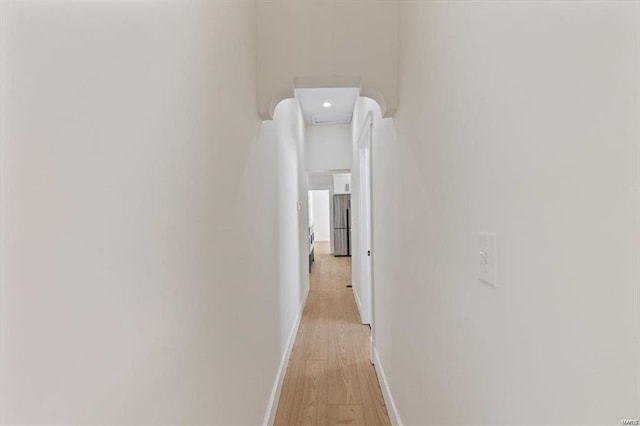 hall with light wood-type flooring and baseboards