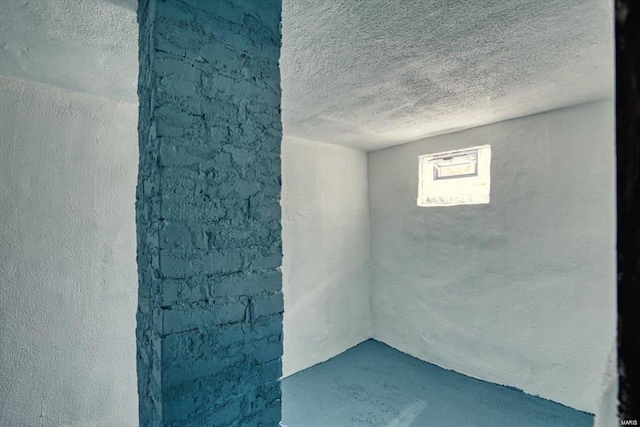 basement with a textured ceiling and a textured wall