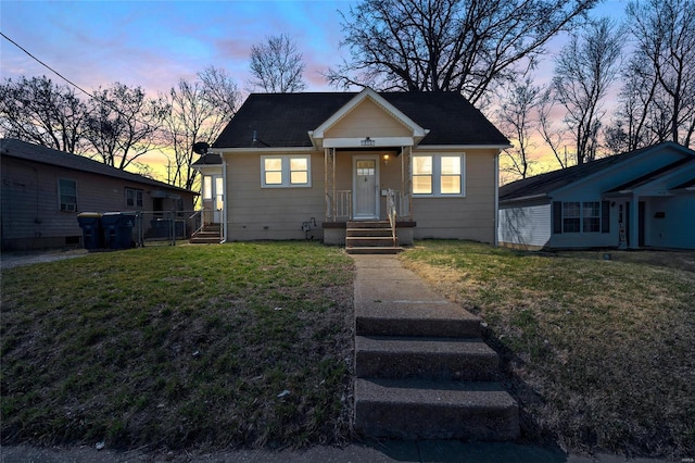 bungalow featuring a front yard and fence