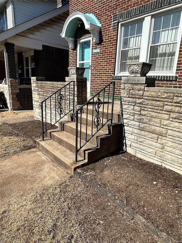 doorway to property featuring brick siding