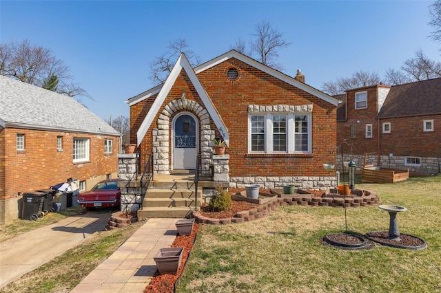 tudor home with a front yard, brick siding, and a chimney