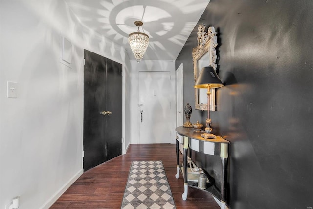 foyer with a chandelier, baseboards, and wood finished floors