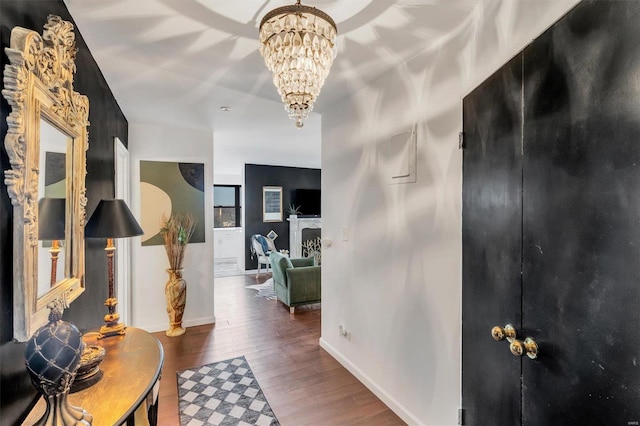 entrance foyer featuring a notable chandelier, wood finished floors, and baseboards