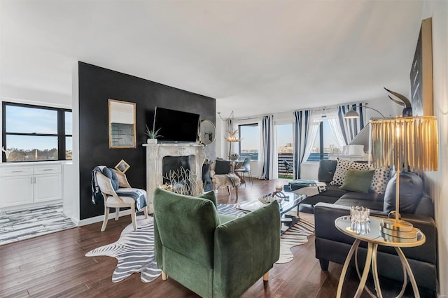 living room featuring a fireplace, baseboards, and wood finished floors