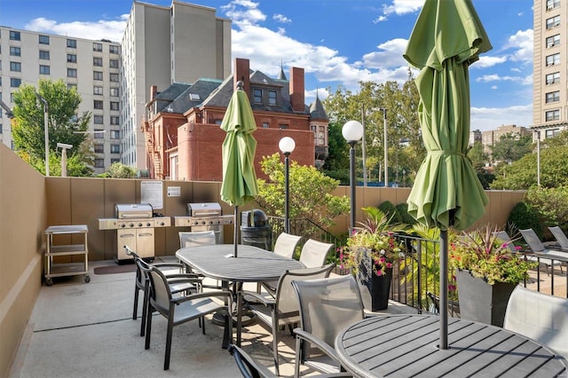 view of patio with outdoor dining space, grilling area, and fence