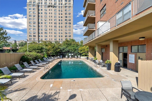 pool with a patio and fence