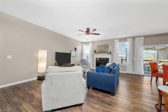 living area with a healthy amount of sunlight, baseboards, and wood finished floors