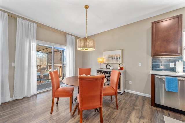 dining area with baseboards and dark wood-style flooring