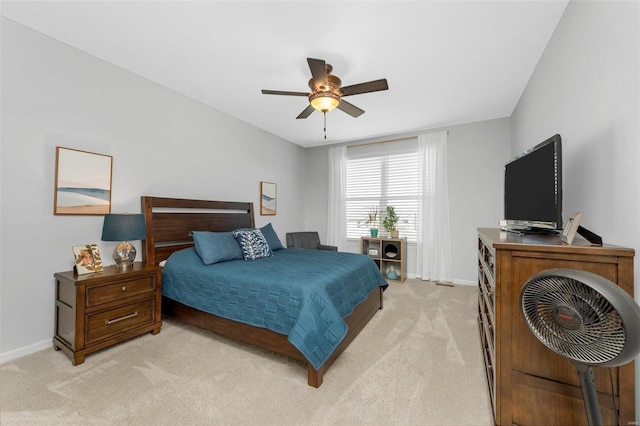 bedroom featuring light colored carpet, ceiling fan, and baseboards