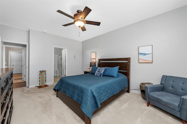 bedroom with light carpet, a ceiling fan, baseboards, and connected bathroom