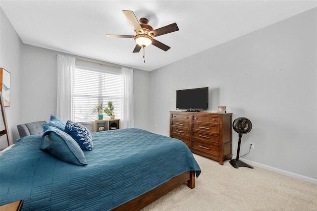 bedroom with light carpet, ceiling fan, and baseboards