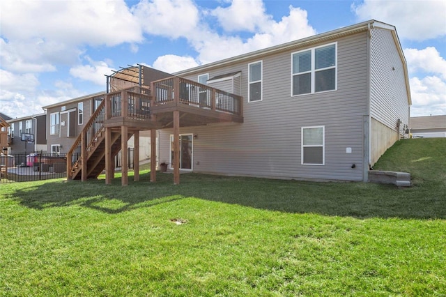 back of property with a lawn, stairway, a wooden deck, and fence