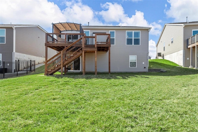 rear view of house featuring fence, stairway, a deck, and a yard