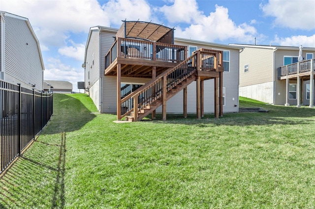 back of property with a yard, stairway, fence, and a wooden deck